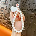 White iridescent bead phone charm with heart-shaped tag and white lobster clasp - White