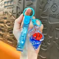Translucent blue liquid sea shell keychain with clownfish toy and glitter strap design - Red Small Fish
