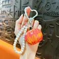 Creative resin apple charm keychain with elegant pearl beaded strap and silver heart clip - Orange