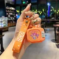 Handgehaltener orangefarbener KPOP Demon Hunters TV-Schlüsselanhänger mit Girlgroup-Motiv - Leuchtend / Orange