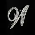 Primer plano de un elegante broche plateado con cristales brillantes en forma de letra M - Estilo Letra W (2255) / Plata W