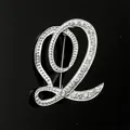 Vista detallada de un broche plateado letra Q con brillantes pedrería de imitación. - Estilo Letra Q (2255) / Plata Q
