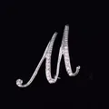 Primer plano de un elegante broche plateado letra M adornado con brillantes cristales blancos - Estilo Letra M (2255) / Oro M