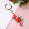 Porte-clés canne à sucre de Noël festif avec nœud rouge et feuilles de houx vert sur fond rose - Env. H 3,8-5,6 cm, L 2,6-3,8 cm / Canne de Noël avec Anneau Argenté