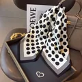 Detailed shot of polka dot silk scarf with elegant heart-shaped brooch accessory - 70cm x 70cm / Dots and Lines