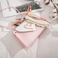 Close-up of pink mini crossbody bag with heart clasp and elegant silk scarf detail - Mini Style (20x5x12cm) / Pink
