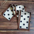 Close-up of a vintage French-style polka dot narrow silk scarf on a wooden background - Rice Brown Polka Dot / 10*100cm
