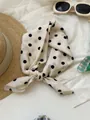 Close-up of a retro cream cotton linen square scarf with black polka dots tied in a knot - 01-meter Bottom Polka Dot