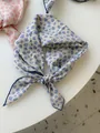 Detailed close-up of a blue floral cotton linen square scarf with tied knot decoration - 05 Small Flower Basket