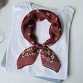 Dettaglio di un foulard in seta bordeaux con stampa floreale su una maglietta bianca - Lm58 - cross seed flower, red / 58*58cm