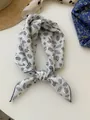 Close-up of cotton linen bandana with black floral print and blue hem border - 08 Leaves With White Background