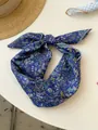 Detailed view of a purple floral cotton linen scarf tied in a decorative knot - 09 Full Of Flowers And Navy Blue