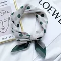 Primo piano dettagliato di un leggero foulard a pois verdi su sfondo di tessuto bianco - Lm58 - polka dot center frame, white background / 58*58cm
