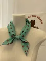 Detailed view of a mint green floral cotton linen scarf elegantly tied on a display mannequin - 29 Small Green Bouquets