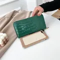 Élégant long portefeuille vert à motif crocodile, montré avec téléphone pour la taille - Vert