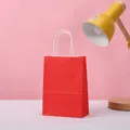Vibrant red kraft paper gift bag with white twisted handles for party and candy - Red