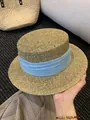 Close-up of the fine woven texture and the light blue fabric band on the French straw hat. - M (56-58cm) / Blue