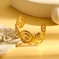 Detailopname van een gouden roestvrijstalen manchetarmband met geometrisch spiraalontwerp - Continue Spiraaltextuur Holle Stijl (S834) / Goud