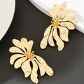 Vista dettagliata di orecchini a lobo a fiore irregolare con finitura in oro martellato e design - Oro