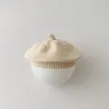 Minimalistische crèmekleurige gebreide babybaret op een witte bolvormige standaard - Licht Kaki Fopspeen