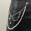 Dettaglio della catena in vita multistrato con finte perle e oro su pantaloni di pelle - 08 Kc Oro 11873