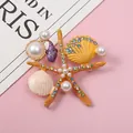 Vue détaillée d'une broche étoile de mer avec strass colorés et perles blanches - Orange