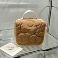 Detailed view of brown quilted floral makeup bag with pink handle and colorful zipper - 14.5*8.5*14.5cm / Brown