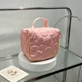 Close-up detail of pink quilted cosmetic bag with floral stitching on a display stand - 14.5*8.5*14.5cm / Pink