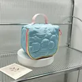 Detail of cute blue quilted floral cosmetic bag with pink handle on white display stand - 14.5*8.5*14.5cm / Light Blue
