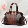Glänzende braune Handtasche mit luxuriöser Krokodilprägung und zwei Tragegriffen - L33 B14 H21 / Kaffeebraun