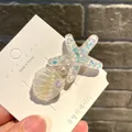 Detailansicht einer Haarspange mit glitzerndem Seestern, Muschel und Perlen im Ozean-Stil - Gebogene Muschel Seestern / Weiß
