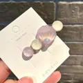 Haarspange im Meerjungfrau-Stil mit lila Muschel und Perlen auf weißem Display-Kärtchen. - Gebogene Muschel mit Perlen / Lila