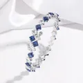 Elegant silver-colored open bangle featuring square-cut blue and white zircon gemstones - Blue