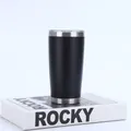 Primer plano de vaso térmico 20oz de acero inoxidable negro mate sobre un libro decorativo - Negro
