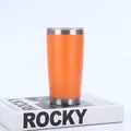 Vaso de acero inoxidable de 20 oz aislado al vacío en color naranja sobre un libro blanco - Naranja