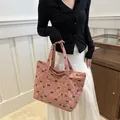 Stylish pink corduroy tote bag with black bow pattern and elegant quilted diamond stitching - Pink