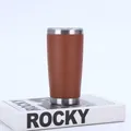 Close-up view of a 20oz brown stainless steel vacuum insulated tumbler placed on a white book - 20oz / Red