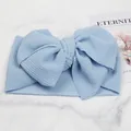 Close-up of infant headband featuring a large light blue bow with bubble texture fabric - Light Blue