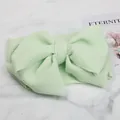 Detail view of light green bubble textured fabric child headband with large bow - Mint Green