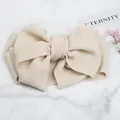 Detailed macro view of cream textured waffle fabric baby headband with large bow - Beige