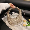 Fashionable metallic gold woven noodle handbag with creative circular handle design - Gold