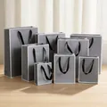 Premium grey matte gift paper bags with black ribbon handles shown in various sizes - (Vertical) 12L*5.7W*16H / Grey (White Frame)