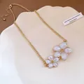 Vintage gold chain necklace featuring delicate white enamel flower pendants for women - Choker Necklace / Beige