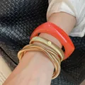 Four-piece metallic gold and orange resin bracelet set worn on wrist with black bag - 22# Bracelet - Gold - Orange (three-piece Set)