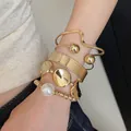 4-piece gold metallic irregular bangle set with pearl detail on wrist. - 39# Bracelet - Gold (5-piece Set)