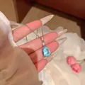 Detailed macro view of a light blue teardrop crystal pendant necklace on silver chain - Pear Shaped Light Blue Faceted Gem Pendant (X2213) / Silver