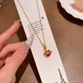 Light luxury gold-colored necklace featuring a sparkling red cat paw pendant design - Cat Paw Shape Red Main Stone with Rhinestone Halo Pendant (X2170) / Gold