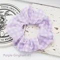 Detail view of a purple and white gingham fabric hair scrunchie for women styling - Purple Plaid 1