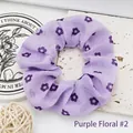 Macro view of purple floral fabric scrunchie showing delicate flower pattern and texture - Purple Flowers 2