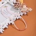 Detaillierte Nahaufnahme einer rosa Muschelperlenkette mit Perlen und rosa Steinen. - Rosa